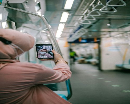Commuter using smartphone on Jakarta MRT